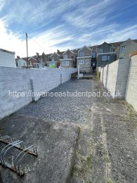 Long low maintenance garden with clothes airer, secure bike store and decking with table and seating